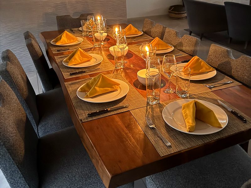Mesa larga puesta con velas para una cena en una villa de Playas del Coco